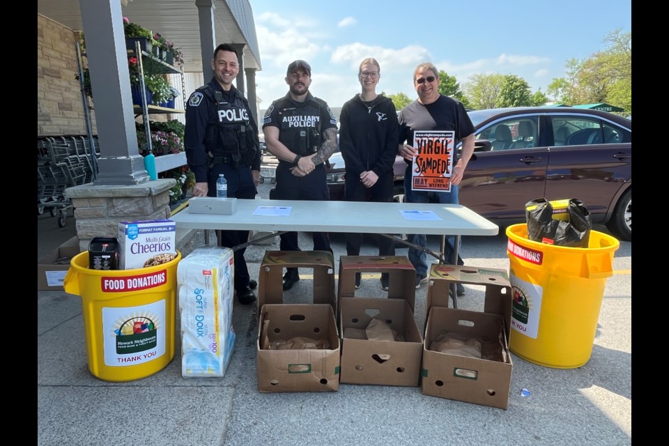 L-R - Constable Mike Malachowsky, Auxiliary officer Kenneth Ferguson, store clerk Emma Bartel, Phil Leboudec, who couldn't resist an opportunity to plug this weekend's Virgil Stampede. 