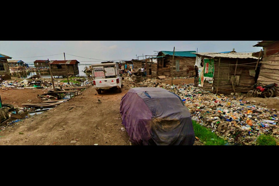 A street view of garbage heaps entering a lagoon in Lagos, Nigeria.
