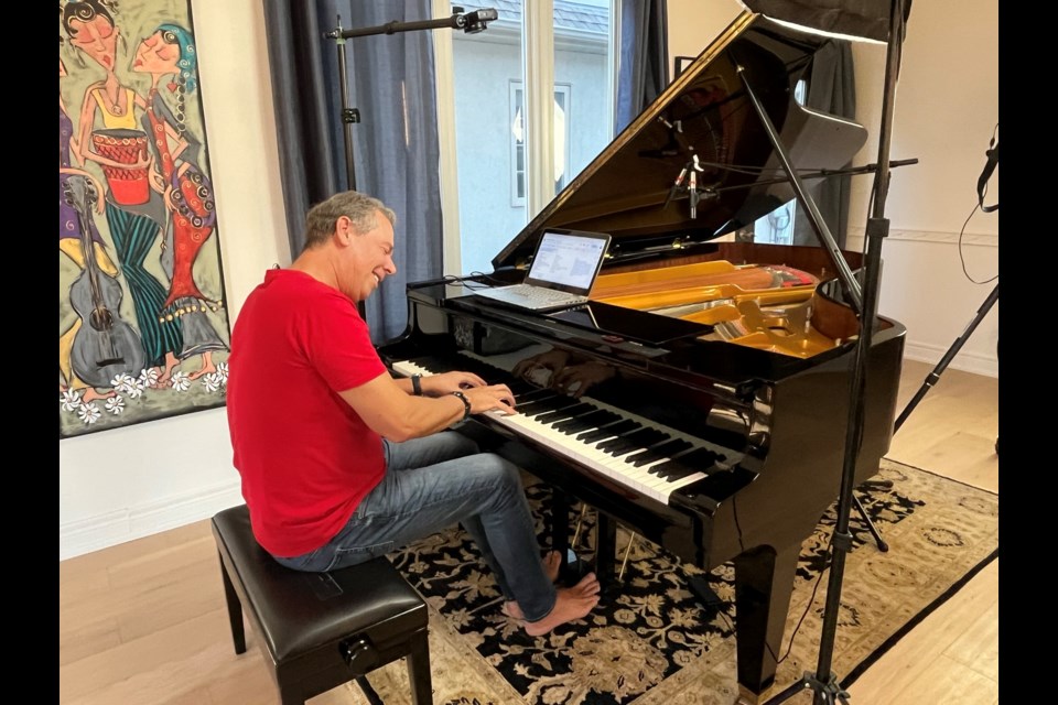 A barefoot Paul Tobey playing his piano in his home studio in NOTL. File Photo
