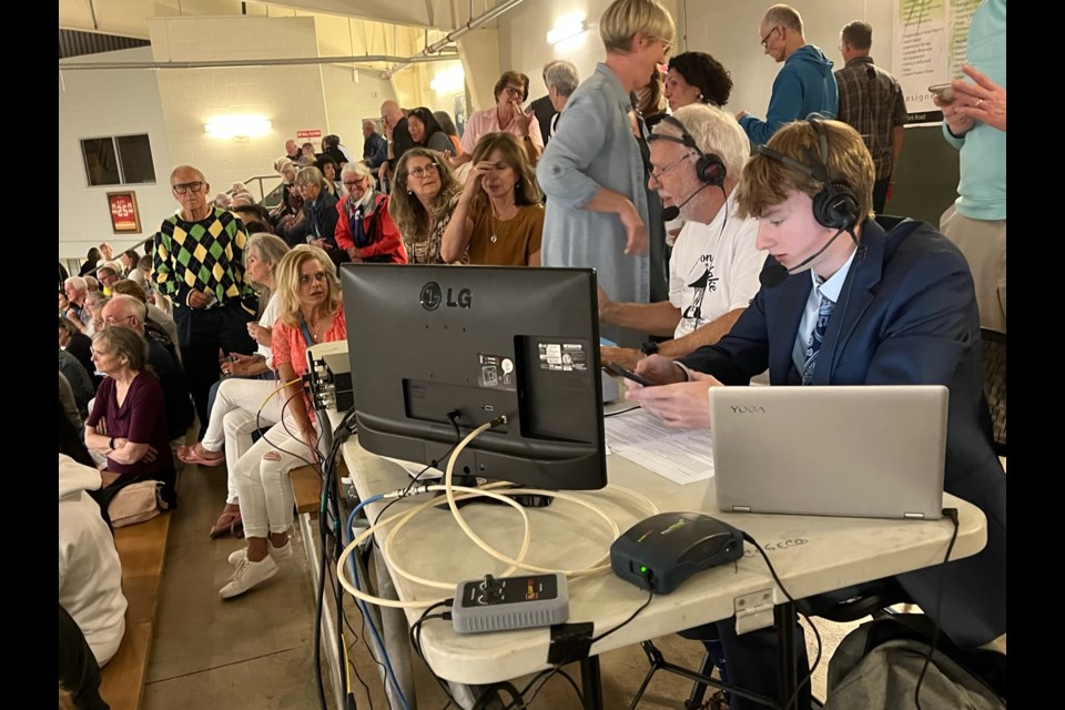 Pickleball president John Hindle and Noah Vogel at the broadcast table in the arena with a full crowd surrounding them on pro night Friday