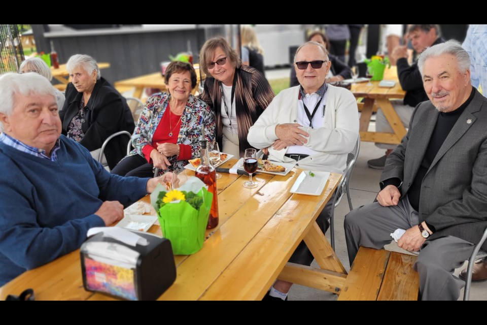 Lena (left, in red) and Gary Pillitteri (right, sitting) with family and friends on the BarrelHead patio. 
pizza patio. 