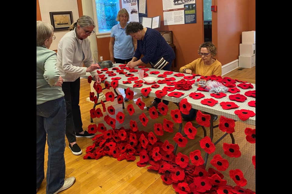 The Poppy Brigade is hard at work at the NOTL Museum attaching poppies to nets for installation at the Royal Canadian Legion. 