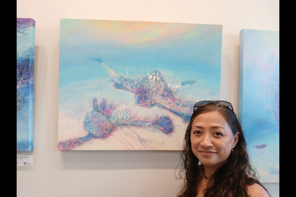 Grace Marquez with Afterlife Swept Away, one of the paintings in Immersion, her exhibit at the Pumphouse Arts Centre.