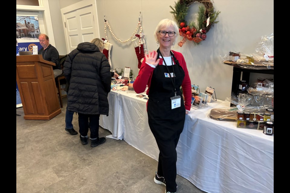 Volunteer Julie Forrester Clark greets guests arriving at the pumphouse Holiday Market. By noon Saturday, more than 900 visitors had come to see the gift show and sale, which continues this week.