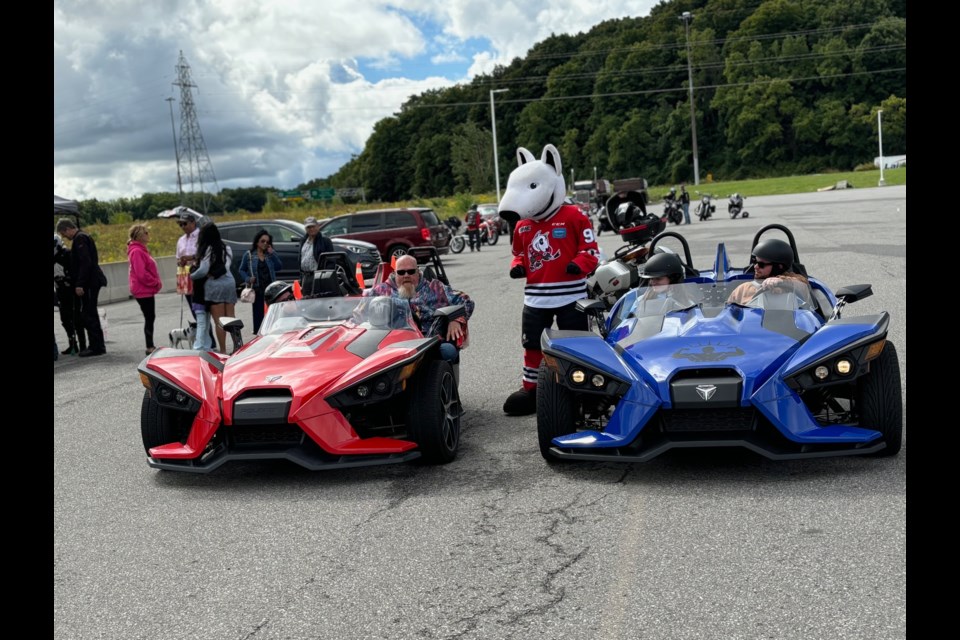 Bones, the Ice Dogs mascot, checks out the two Polaris Slingshots as they get ready to leave on the Ride4Paws fundraising poker run.