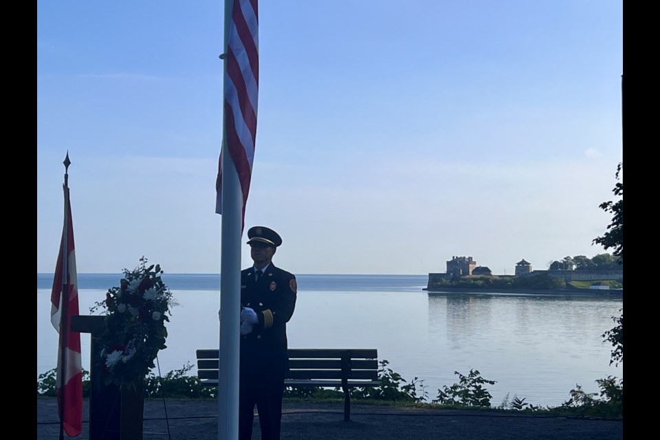 Fire Chief Jay Plato raises the American flag, Old Fort Niagara, New York, in the background, at the 9/11 memorial service Wednesday morning.