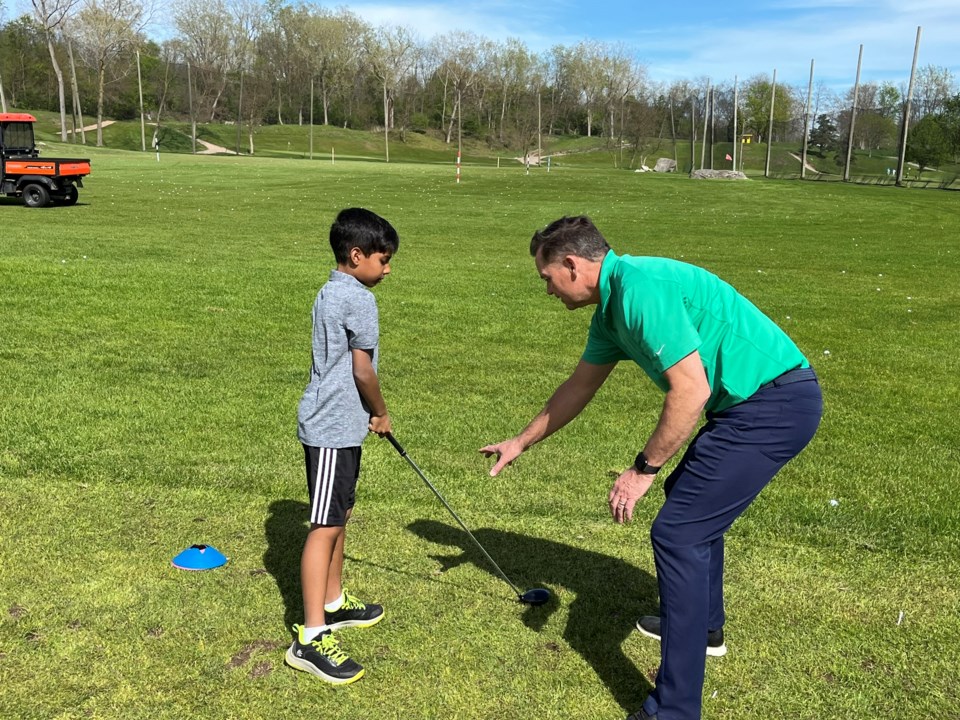 st-davids-school-golf-principal-carl-glauser-helps-eli-pfeffer-with-his-setup