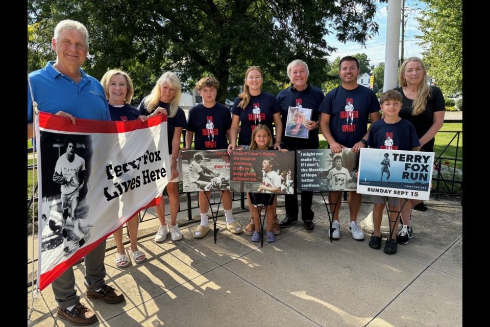 Deputy Lord Mayor Erwin Wiens raised the Terry Fox Run flag at the town hall with Coun. Wendy Cheropita, Regional Coun. Andrea Kaiser (right), run organizer Joan King, with Lucas, Sarah and Sophia Pillitteri, Dave Eke, and Mike and Leo Pillitteri, the family of Debbie Eke, who will be honoured at this year's run. 