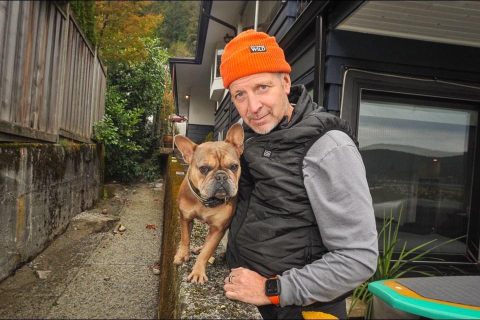 Panorama Drive resident David Goodman and dog Tiller are happy to be back home after his residence flooded in atmospheric river storm. Goodman said there were no emergency accommodations on the North Shore that accept pets. | Paul McGrath / North Shore News