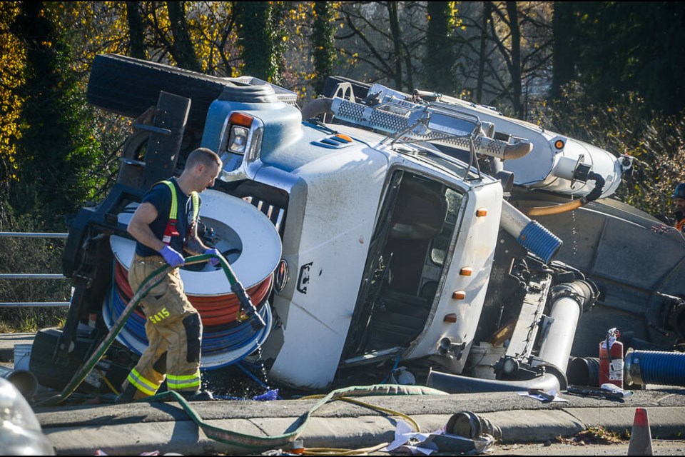 Crews work to clean up the scene surrounding a flipped vacuum truck on Mountain Highway in 2023. | Nick Laba / North Shore News 