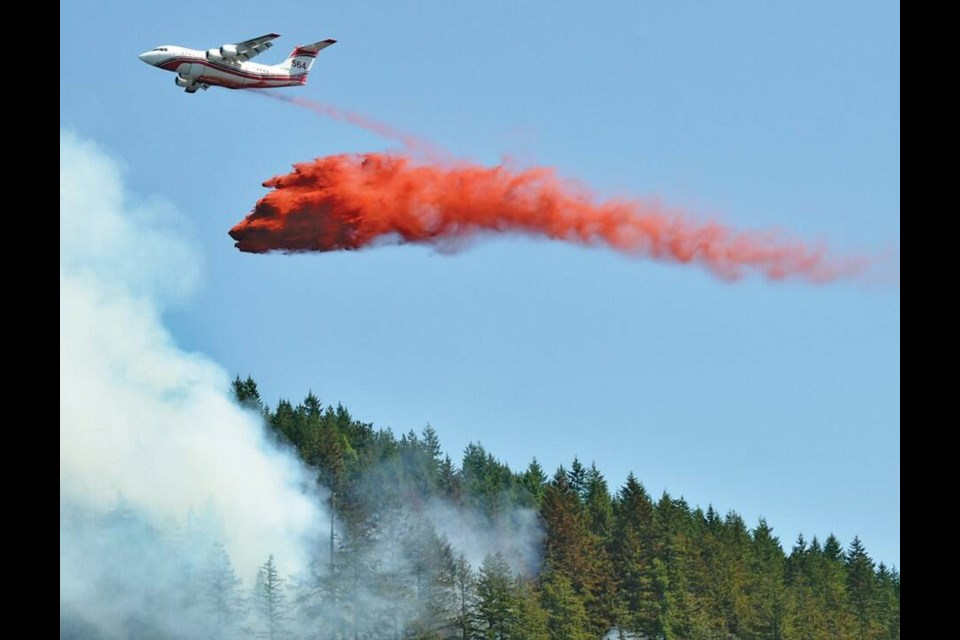 An airtanker dumps a load of fire retardant on a wildfire burning off Highway 99 above Horseshoe Bay in June of 2023. | Paul McGrath / North Shore News 
