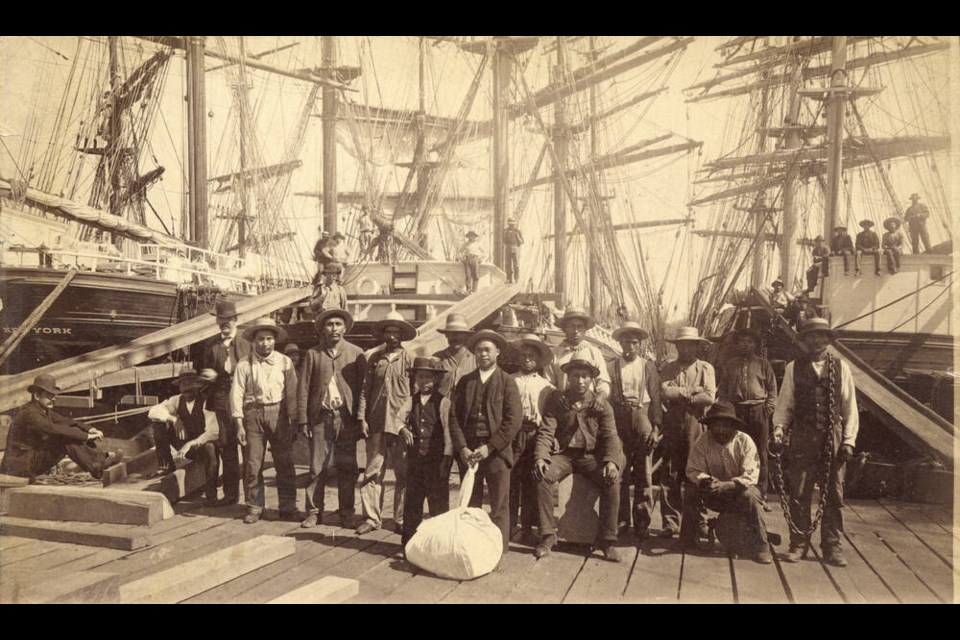 William Nahanee (centre) poses with a group of longshoremen on the dock of Moodyville Sawmill in 1889. | City of Vancouver archives 