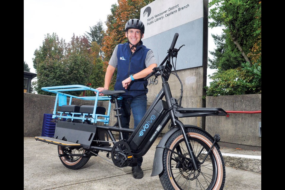 District of North Vancouver Coun. Jordan Back gets ready to ride a longtail e-cargo bike, available for rent from the Capilano library branch. Back introduced a motion for the program in 2023. | Paul McGrath / North Shore News 