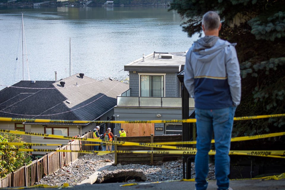 A Deep Cove resident looks over extensive damage to an evacuated property on Panorama Drive in North Vancouver. | Nick Laba / North Shore News 