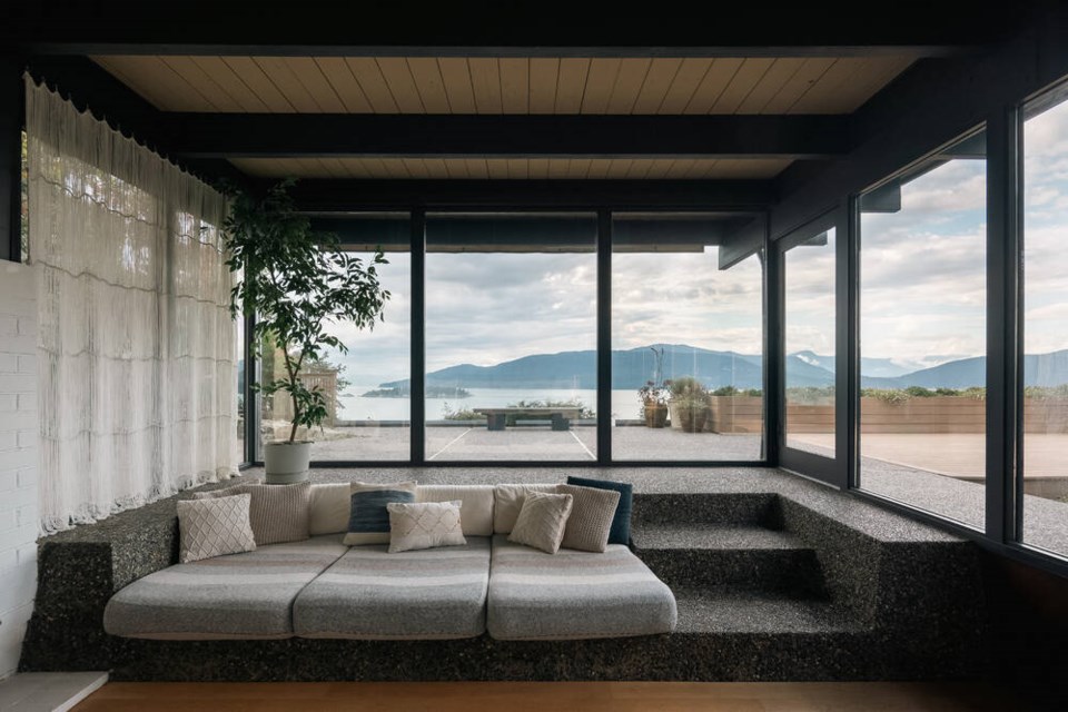 A sunken living area looks out to the courtyard and ocean behind, through floor-to-ceiling windows. | 360 Home Tours 