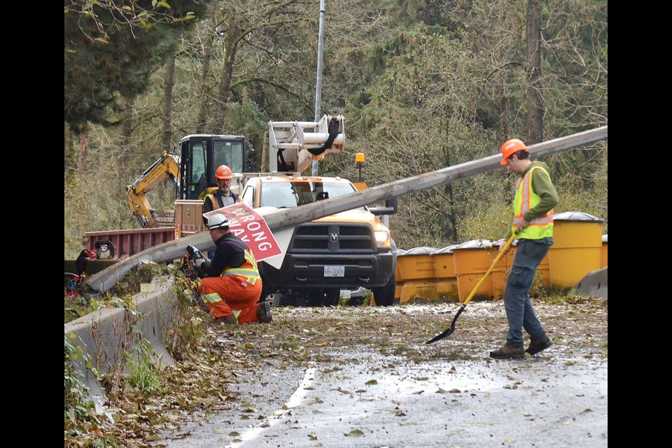 Crews clear the westbound Lynn Valley exit off Highway 1 in North Vancouver after gusty winds caused a tree to fall and knock down a light pole blocking the exit Friday morning. The blockage was cleared before noon. | Paul McGrath / North Shore ߣ 