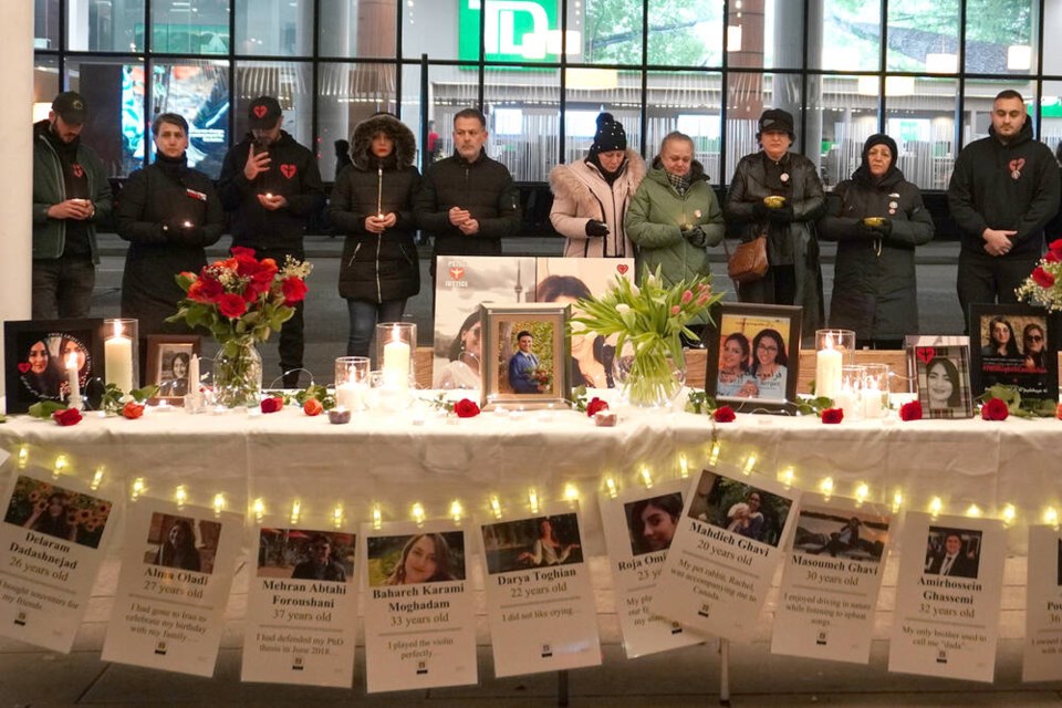 Families of Flight PS752 victims gather at a memorial, holding candles in remembrance of their loved ones. | Hamid Jafari / North Shore News 