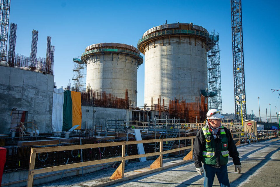 A PCL Construction worker stands in front of the two sludge digesters overlooking the North Shore Wastewater Treatment plant on Wednesday, Jan. 29. | Nick Laba / North Shore News 