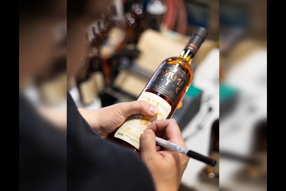 Distillery partner and general manager James Lester signs a bottle of Sons of Vancouver’s Realms of Rye Release No. 01 ‘Citrus & Botanicals.’ It won Rye Whisky of the Year at the 2025 Canadian Whisky Awards. | Sons of Vancouver 