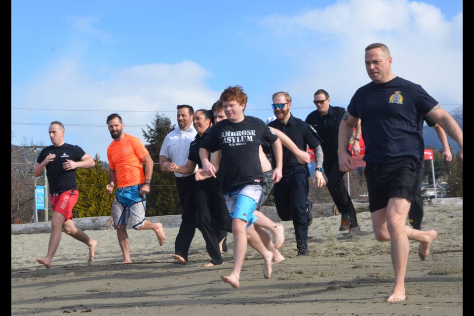 North Vancouver RCMP, West Vancouver Police Department and North Shore Rescue members, along with supporters, take part in a polar plunge off Ambleside Park, March 8, 2023, to benefit Special Olympics BC. | Brent Richter / North Shore News