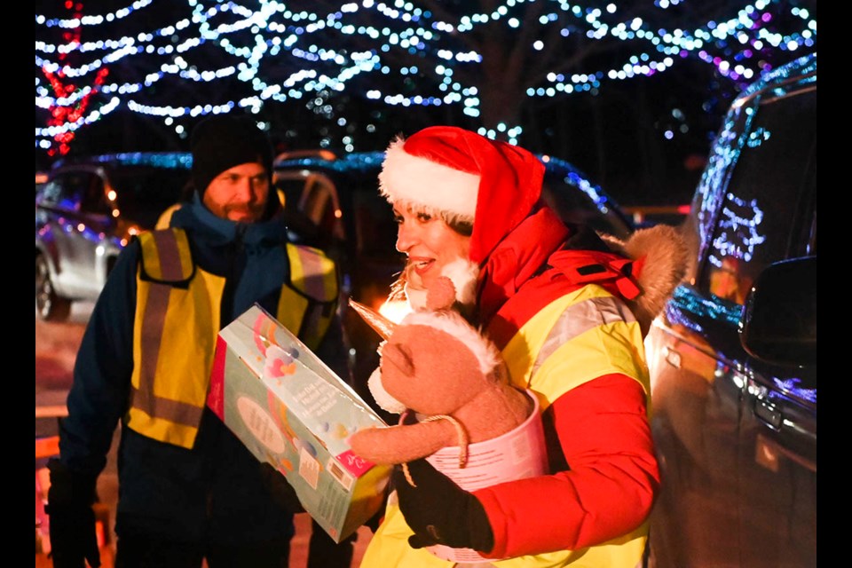 Volunteer Jocelyne Courage with an armful of toy donations at the annual Oakville Firefighters Drive-Thru Toy Drive at Coronation Park.