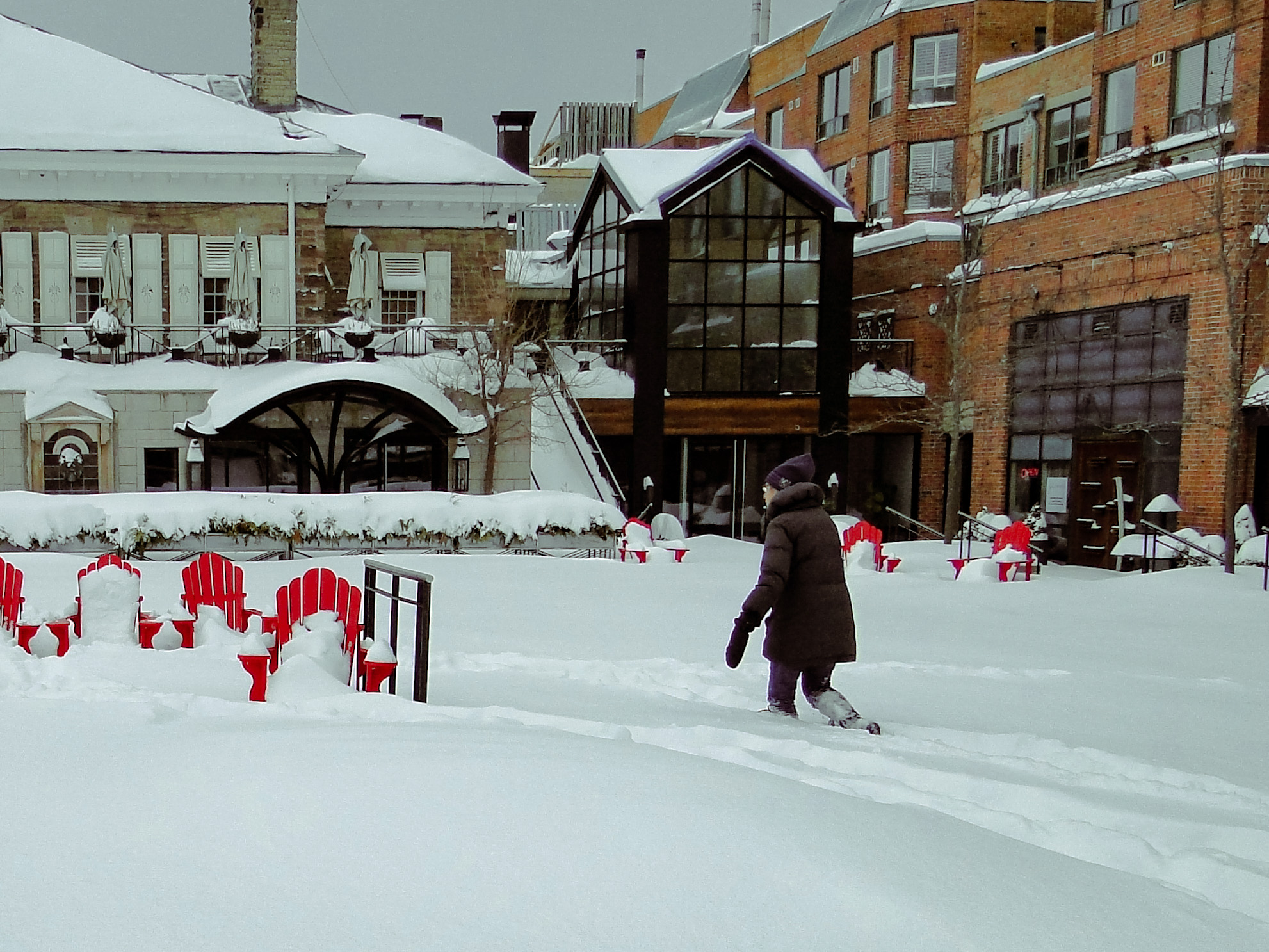 A woman treks through the snow in Town Square in Downtown Oakville. | Mumin Mian