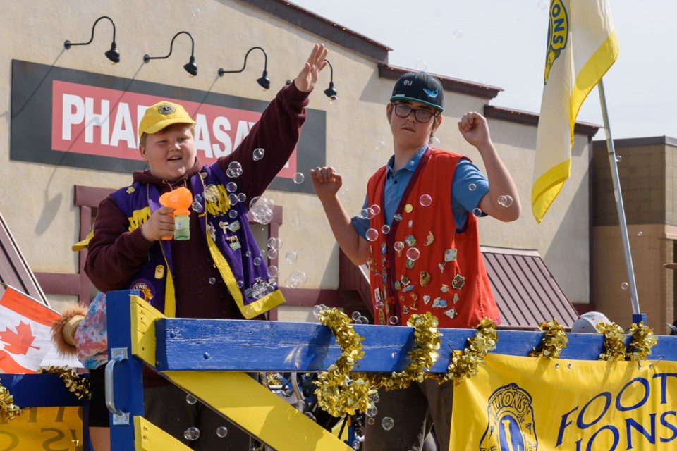 Members of the Lil Legendary Leos ride a float and wave to the crown during the Diamond Valley Parade in Diamond Valley on June 3, 2023. 