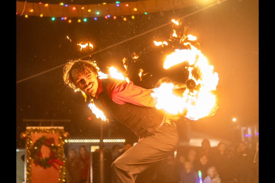 Indigo Circus fire dancer Mr. Skinny twirls a flaming staff at the McArthur Stage for Light Up Okotoks 2023 on Nov. 17.