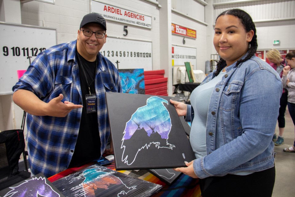 Scott Laboucan sells a painting to fellow artist Desiree Stirling at the Indigenous Artisan Market on June 1.