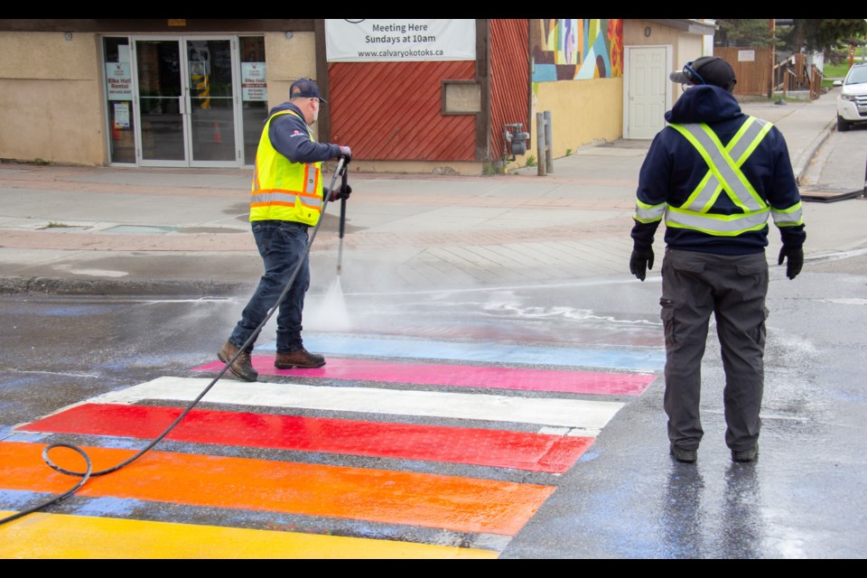 Blue spray paint is being cleaned off the rainbow crosswalk in Olde Towne Okotoks after vandalism was discovered early on the morning of May 30.