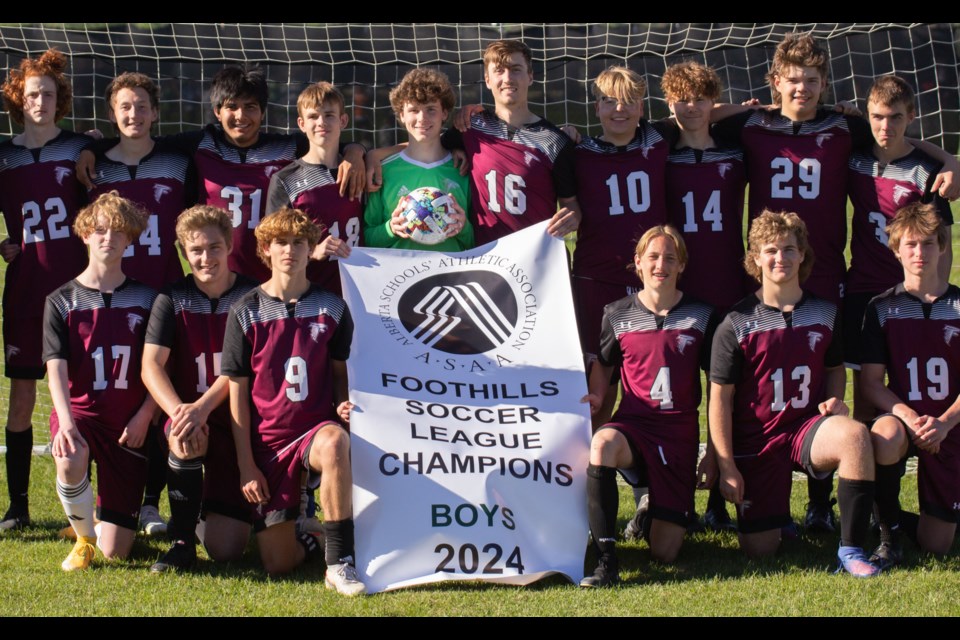 The Foothills Falcons pose with the banner following the Foothills Athletic Council senior boys soccer league championship on June 5.