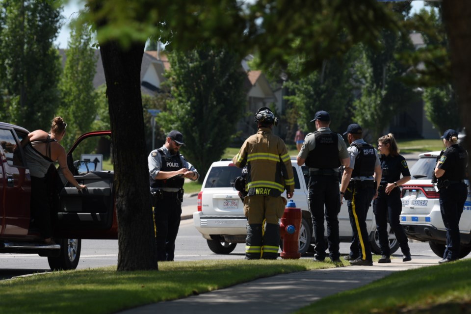 RCMP and other first responders on scene at Woodgate Road near Southridge Drive after a cyclist was struck by a vehicle in Okotoks on July 15.