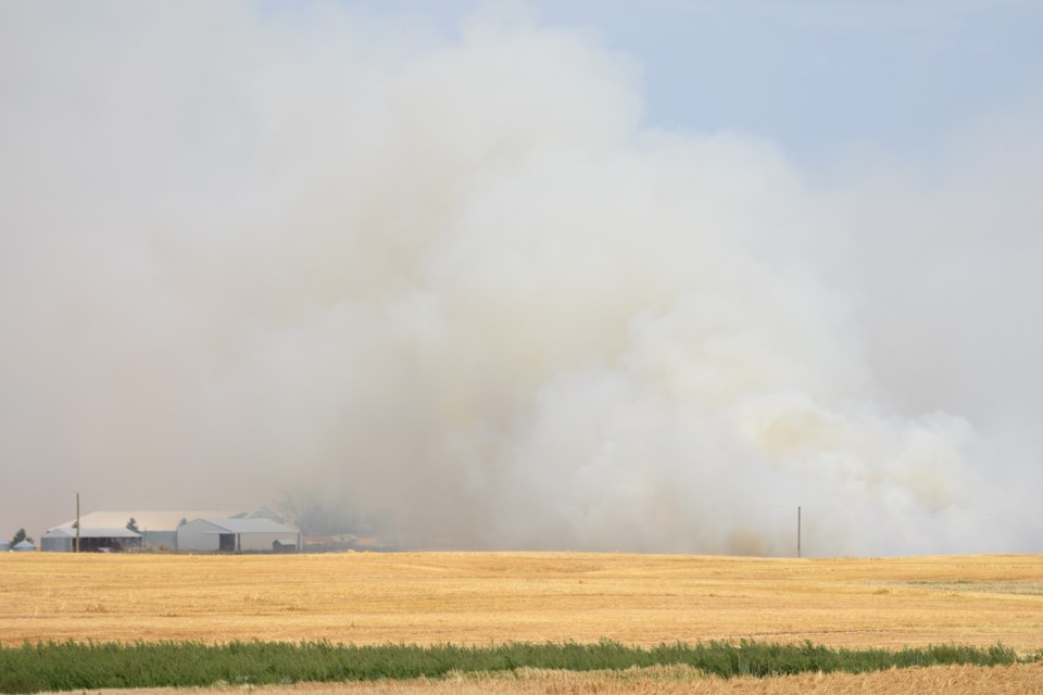 Smoke billows from a grass fire in Foothills County on Aug. 27.