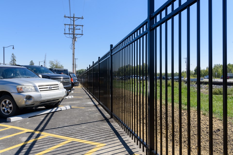 Six-foot-tall fencing along the CPKC tracks and newly-paved parking spaces along Daggett Street in downtown Okotoks on Sept. 5.