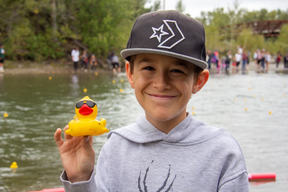 Connor Davis smiles as over 1,500 ducks make their way down the Sheep River during the Simpora Foundation's second annual Rubber Duck Race & Family Fun Carnival on Sept. 14.