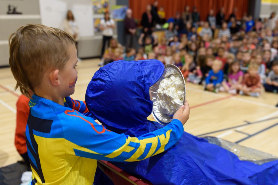 Sulivan Painter pies a teacher at St.Mary’s School in Okotoks on Sept. 20. To raise money for the Terry Fox Cancer Research Foundation, students who bought tickets were entered into a draw to see who could pie a teacher during a day of events at the school.