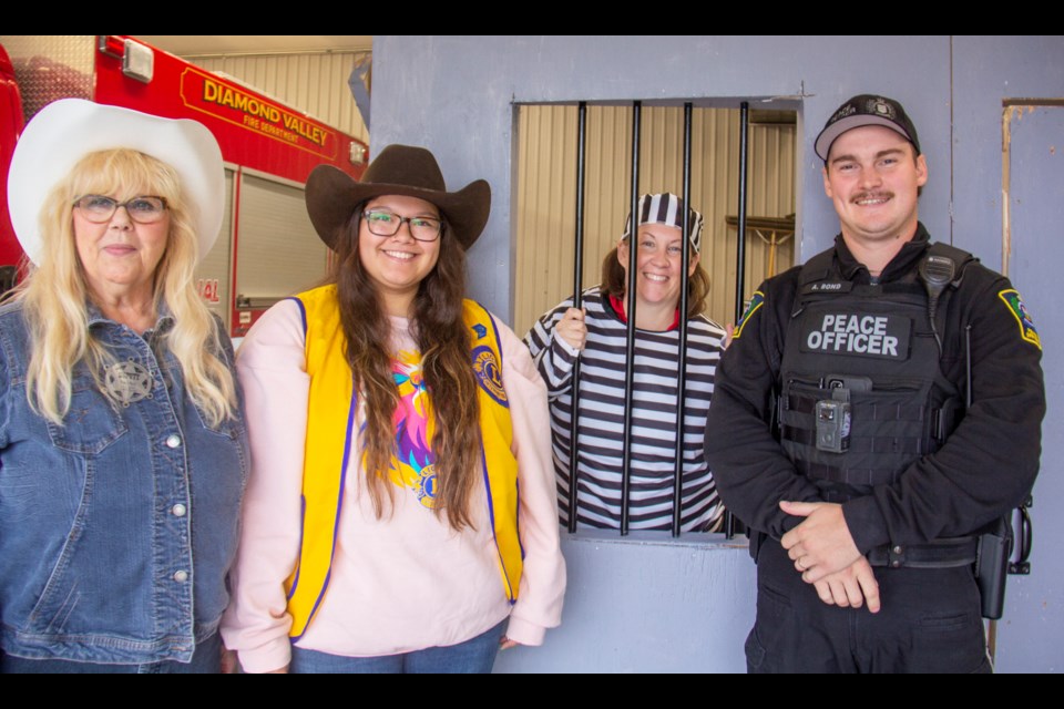 Cowboy Trail Lions Club charter president Alicia Kiri Beer (second from left) stands alongside Diane Bray, Erin Dorman and Andrew Bond at the service organization's jail-and-bail fundraiser on Sept. 20 at the Black Diamond fire station in Diamond Valley.