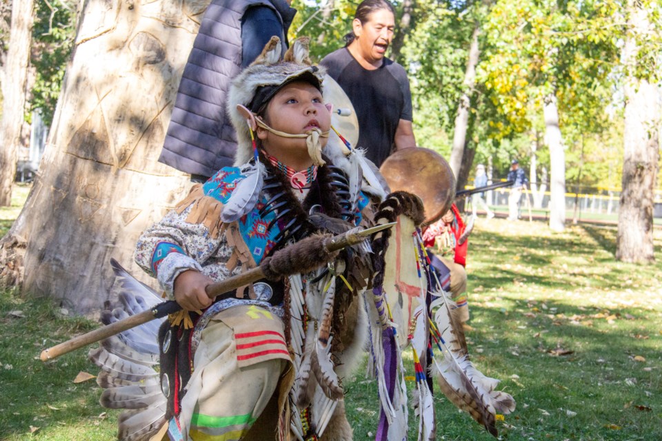 Eden Valley's Creesean Ryder demonstrates men's traditional sneak-up dance during the unveiling of a tree carving by Jared Tailfeathers in High River's George Lane Park on Sept. 28, ahead of Truth and Reconciliation Day.