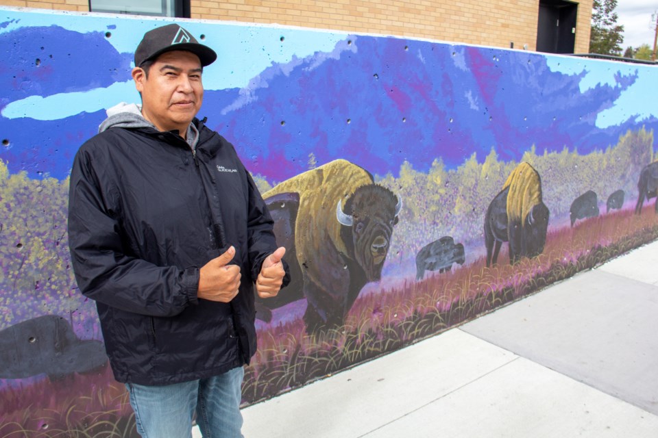 Stoney Nakoda artist Gordon Wesley, pictured on Oct. 2, completed a mural at Okotoks' Arts & Learning Campus Plaza depicting the Sheep River before colonization.