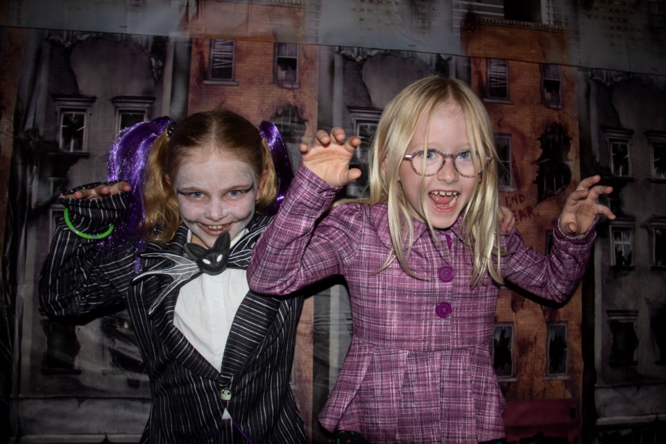 Emery Aasen (left) and Maggie Reimer strike spooky poses at the annual DeWinton Halloween Party on Oct. 19.