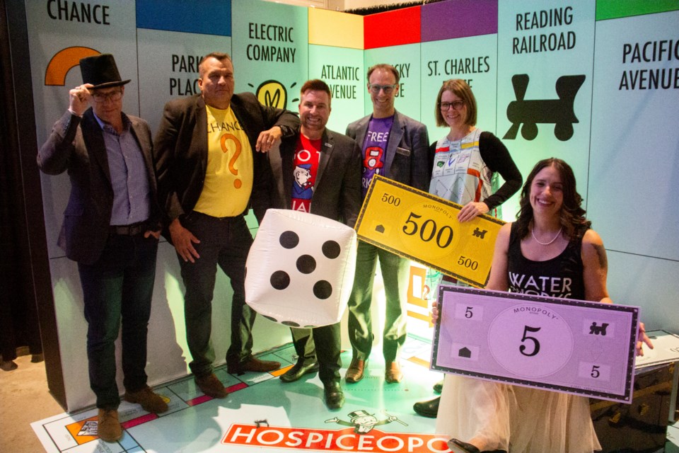 Hospiceopoly 2024 guests pose for a photo in front a Monopoly-themed backdrop on Oct. 18. From left: Foothills MP John Barlow, Town of Okotoks councillors Gord Lang, Oliver Hallmark, Brent Robinson, Mayor Tanya Thorn and Rachel Swendseid. 