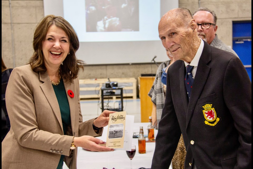 Capt. William Wilson is presented a birthday card by Alberta Premier Danielle Smith during his 100th birthday celebration at HMCS Tecumseh in Calgary on Oct. 25.