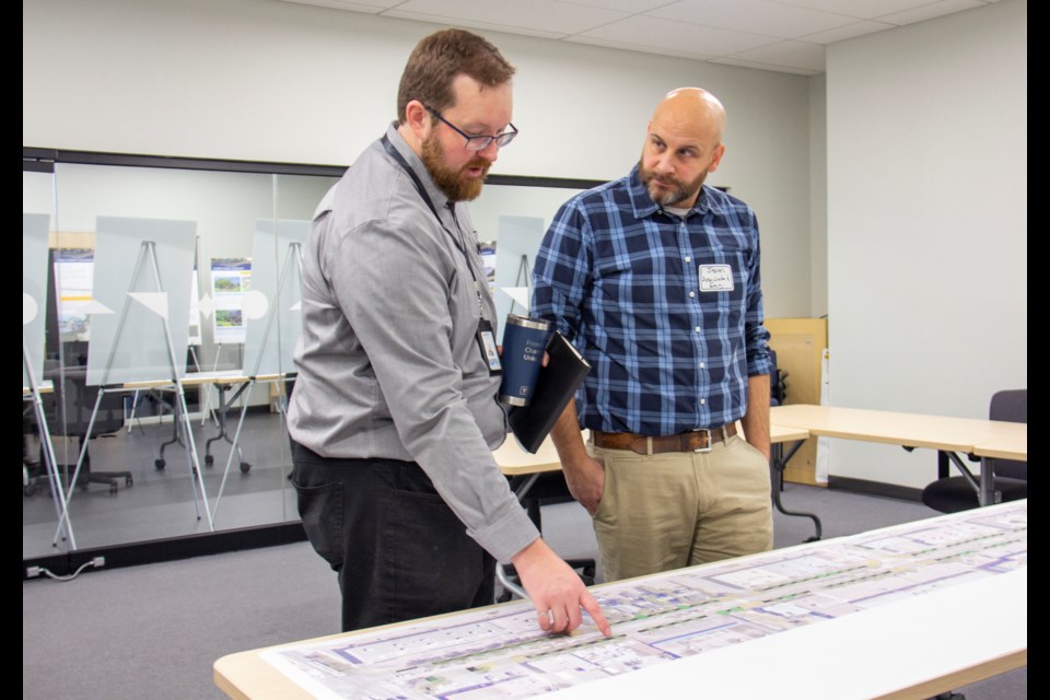 Town of Okotoks senior engineer Mitch Thompson (left) and Associated Engineering landscape architect Jason Bennett discuss the upcoming downtown redevelopment project during an open house at Bow Valley College's Okotoks campus on Nov. 13