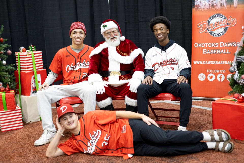 Robert Scalzo (left), Quincey Jenkins (right) and Landon Kauffman pose for a photo with Santa Claus during the Okotoks Dawgs Holiday Hoopla at Duvernay Fieldhouse on Dec. 14.