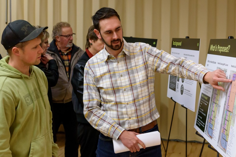 Stantec employee David Symes, right, speaks with Jeremy Stewart during an open house at the Highwood Centre in High River for a data centre proposal in Foothills County on Dec. 11.