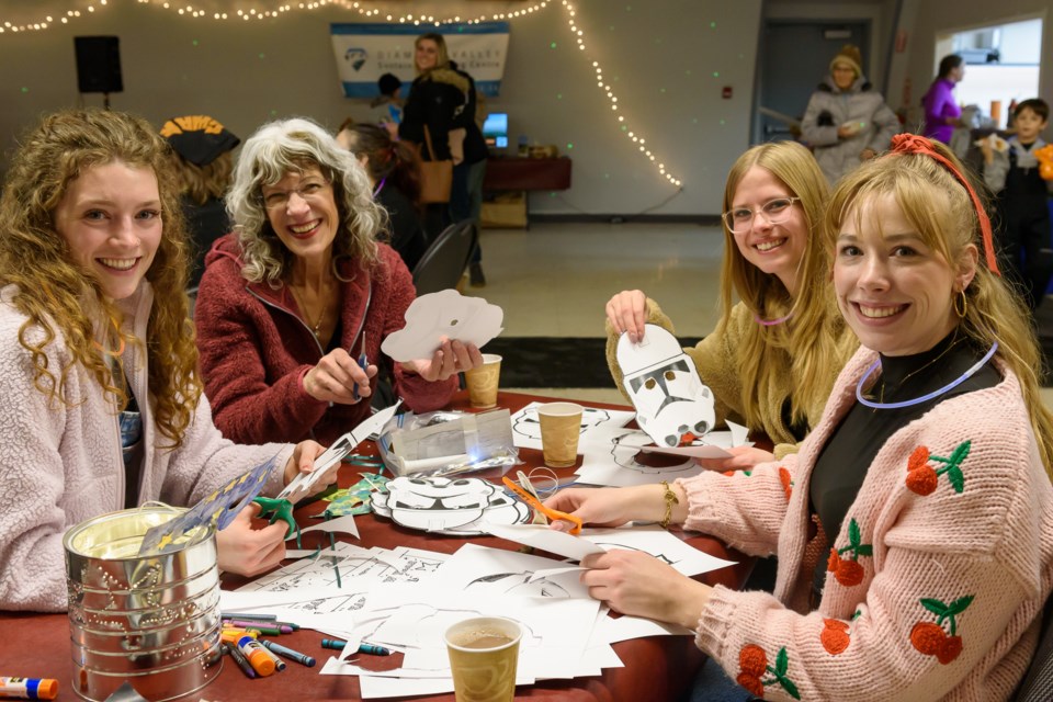 The "Chuckwagon Girls" help prepare crafts during the Starry Night Spectacular at the Flare n' Derrick Community Hall in Diamond Valley on Dec. 31.