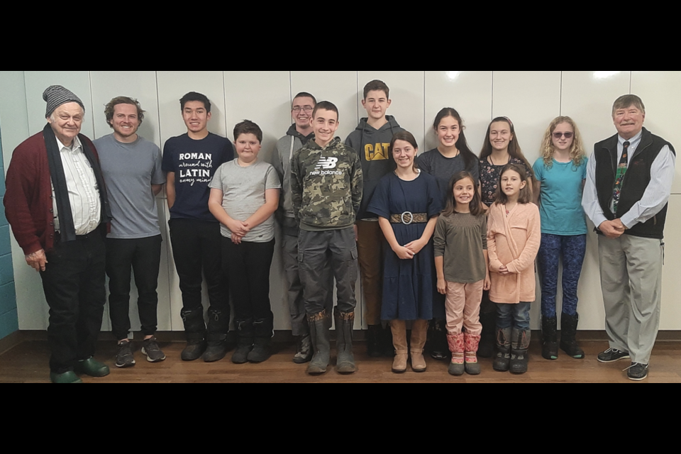 Competitors and judges posed for a photo on Jan. 2, the first day of the Larry Berg Time Trial Puzzle Competition. Back row from left: Larry Berg, Karl-Erik Berg, Joshua Miron, Joseph Fraser, Theodor Radulescu, Avra Miron, Cecily Fraser, Mataya Lawlor and Paul Milligan. Front row from left: Stefan Radulescu, Samuel Fraser, Rebecca Fraser, Marie Fraser and Jacinta Fraser. 