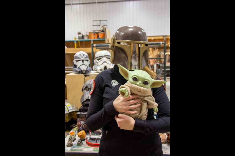 501st Legion member Deez Lees wears a Mandalorian helmet while holding a Grogu ('The Mandalorian') toy with some of her 'Star Wars' collectibles on display in the Diamond Valley Sustainable Living Centre on Oct. 24.