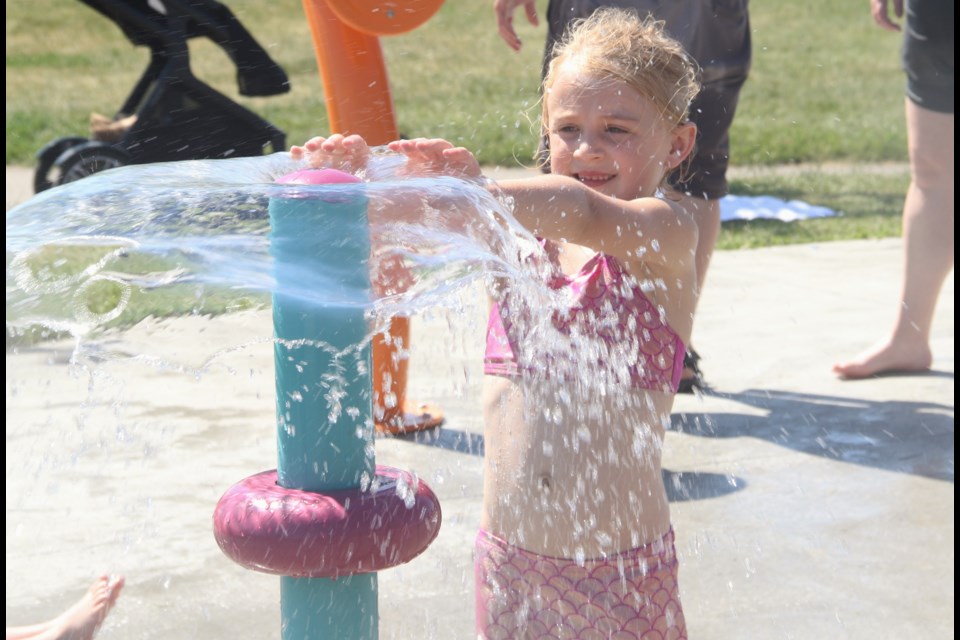 Harlow Piggott plays with a fountain at the spray park in Okotoks on June 28.