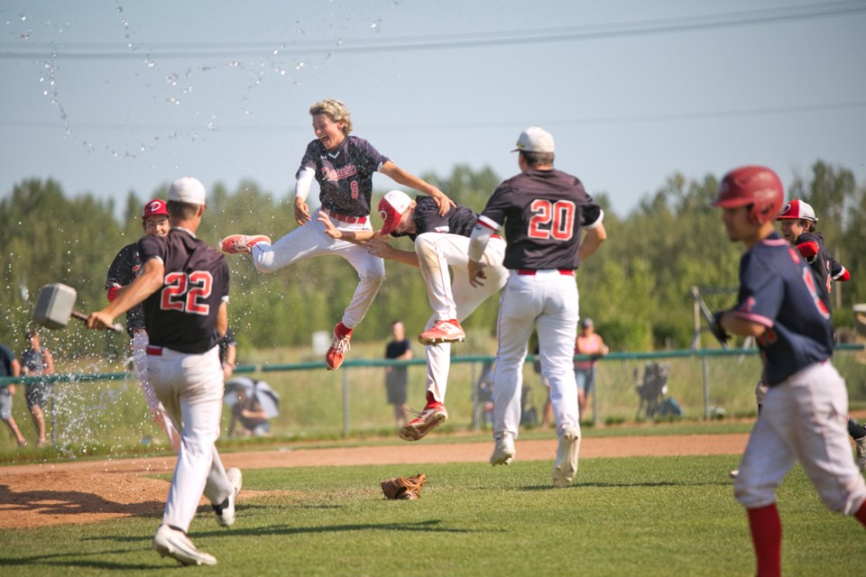 Okotoks Dawgs 15U Black's Deri Steiert-Couture and Karter Andersen celebrate the team's 12-3 win in the 15U AAA provincial final, Aug. 4 at Conrad Field. (Remy Greer/Western Wheel)